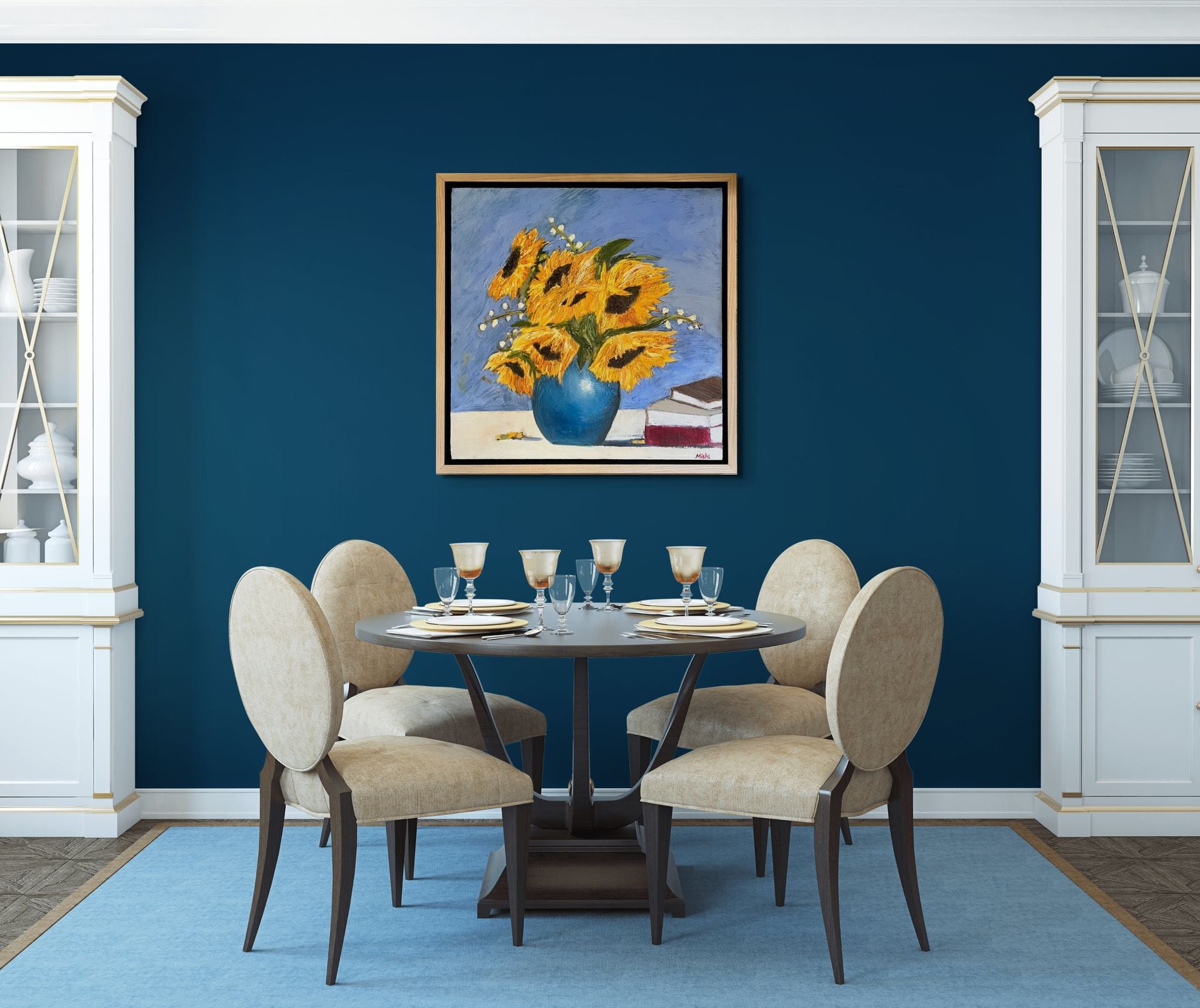 Dining room with a round table and four chairs against a blue wall with a sunflower painting.
